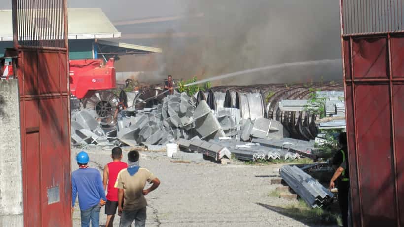 Fumaça densa e chamas em incêndio de grande porte em estabelecimento industrial