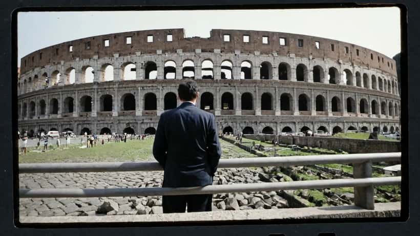 Professionista italiano che consegna documenti riservati a un avvocato in un corridoio del tribunale di Roma
