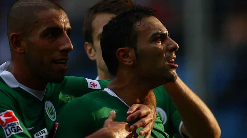 VfL Wolfsburg players in a Bundesliga football match, illustrating the financial stakes of German top-flight soccer