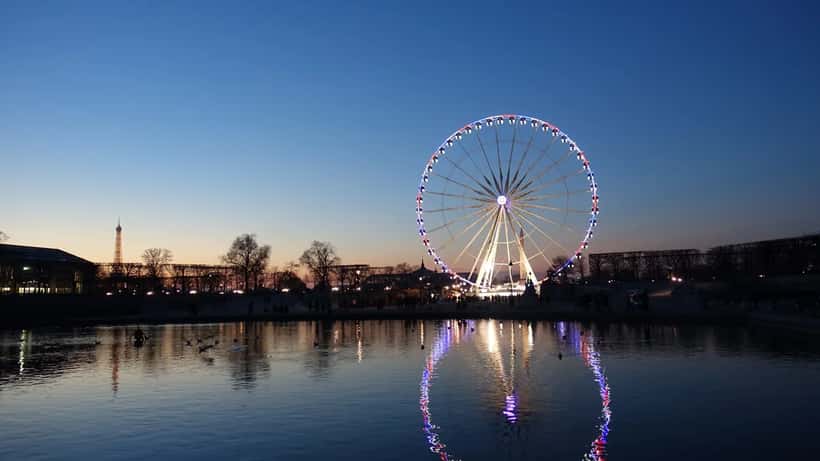 Grande roue illuminée de Paris vue de nuit près du Jardin des Tuileries