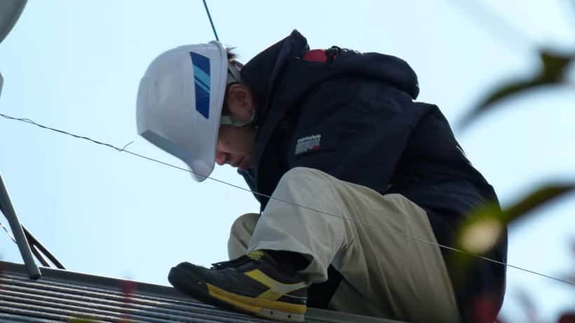 Solartechniker bei der Montage von Photovoltaikmodulen auf einem Hausdach