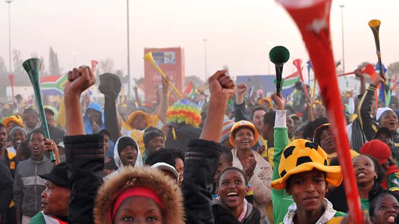 Tifosi che guardano un match dei Mondiali 2026 su uno schermo esterno in piazza