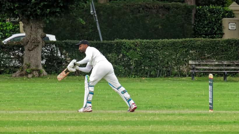 Cricket match in England with overcast skies, players on the field during a county game