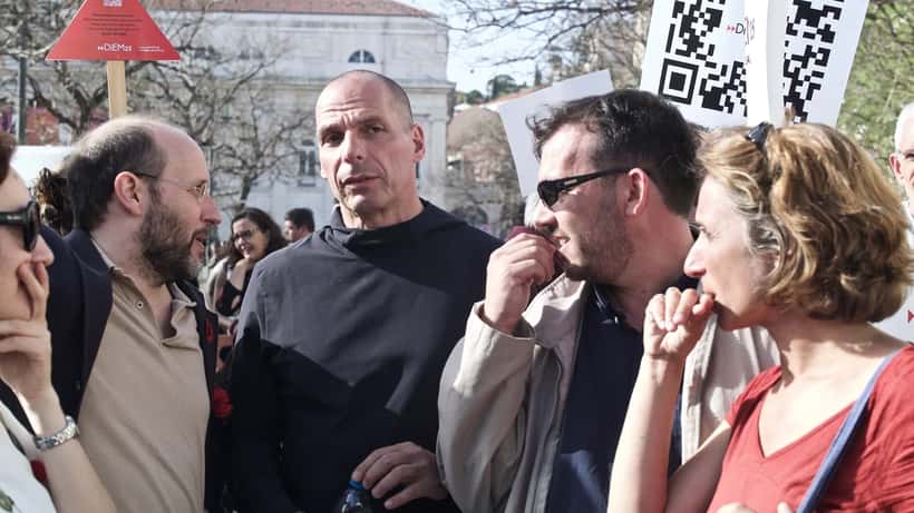 Manifestação do 25 de Abril em Lisboa com participantes e cravos vermelhos, celebração da Revolução de Abril de 1974