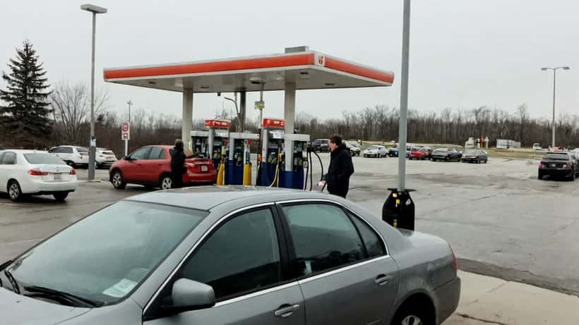 Canadian driver at a gas station in Toronto watching pump prices drop to 173.9 cents per litre in April 2026