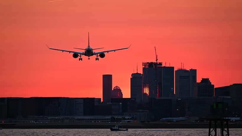 Airbus A220 en approche finale sur la piste, au coucher du soleil