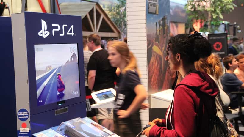 Gaming-Besucher auf der Gamescom in Köln spielen an Konsolen