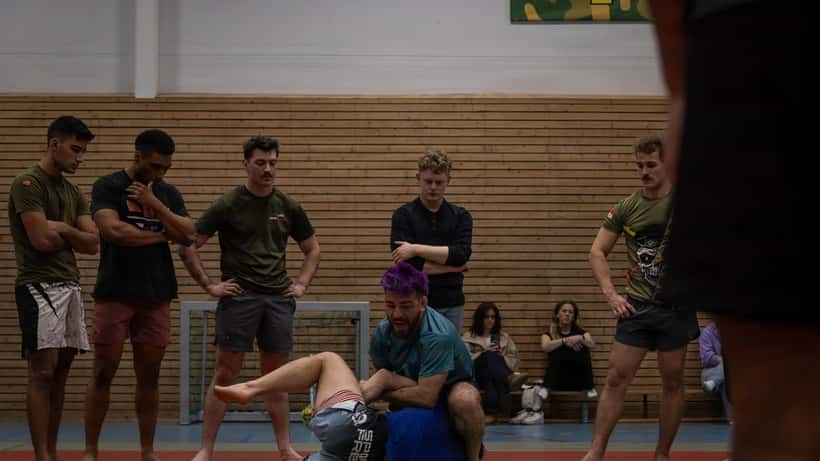 MMA fighters training clinch techniques in combat sports gym 2026