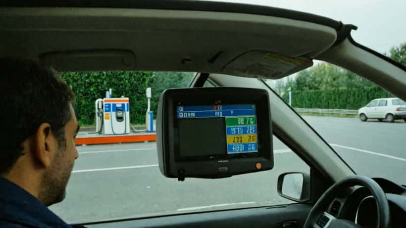 Automobilista italiano al distributore self-service controlla il prezzo della benzina sul display digitale
