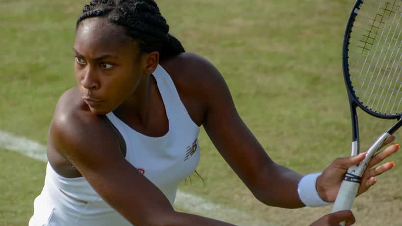 Coco Gauff posando en evento deportivo, sonriendo a la cámara con ropa casual