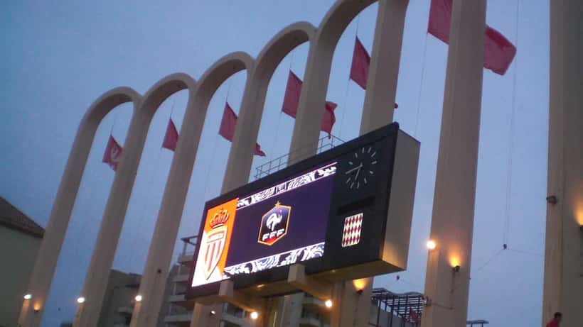Match de football Ligue 1 dans un stade français, joueurs en action sous les projecteurs