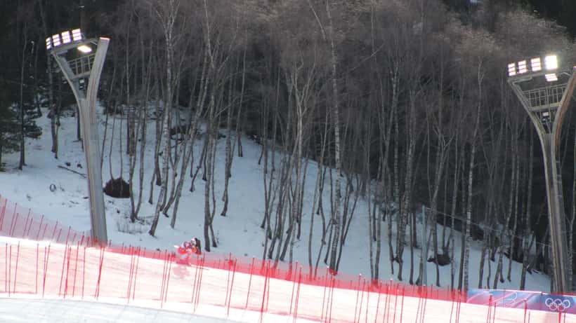 Marco Odermatt en action lors de la descente olympique à Bormio, JO 2026, combinaison de ski suisse rouge