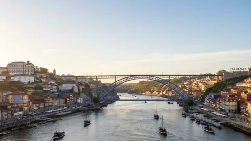 Consultor financeiro português a analisar documentos e gráficos num escritório no Porto