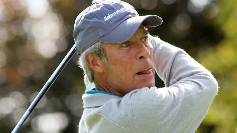 Senior professional golfer teeing off at a championship tournament