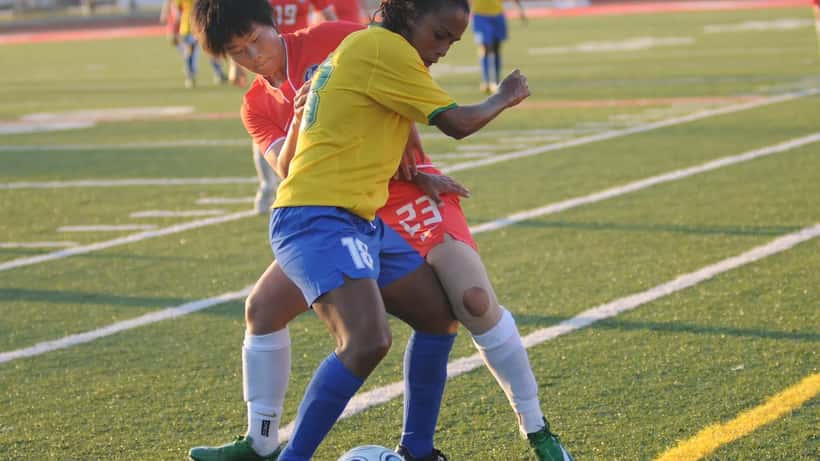 Joueuses de football féminin en plein match international, action sur le terrain
