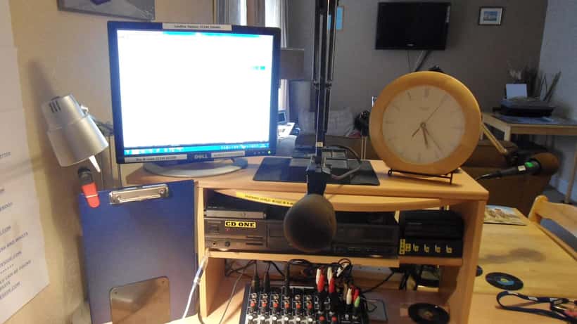 Interior of a UK local radio broadcast studio with microphone and mixing desk