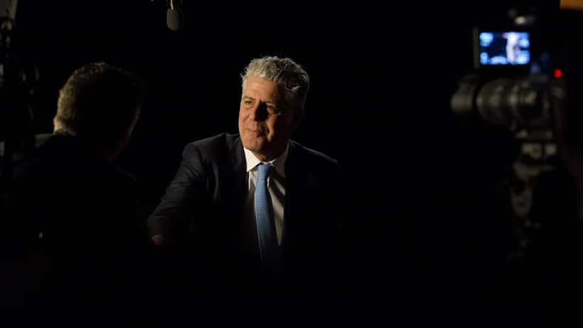 Anthony Bourdain speaking at an event, the culinary icon whose story continues to spark mental health conversations