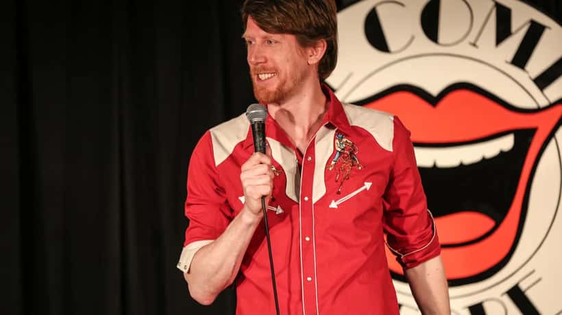 Stand-up komiker med mikrofon på scene, illustrasjonsbilde for artikkel om mental helse blant artister