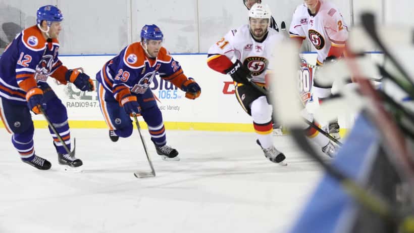 NHL defenceman skating during an AHL outdoor classic, illustrating veteran free-agent contract planning