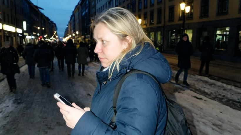 Kvinne ser nervøst over skulderen på en bygate - illustrasjon av personforfølgelse og stalking