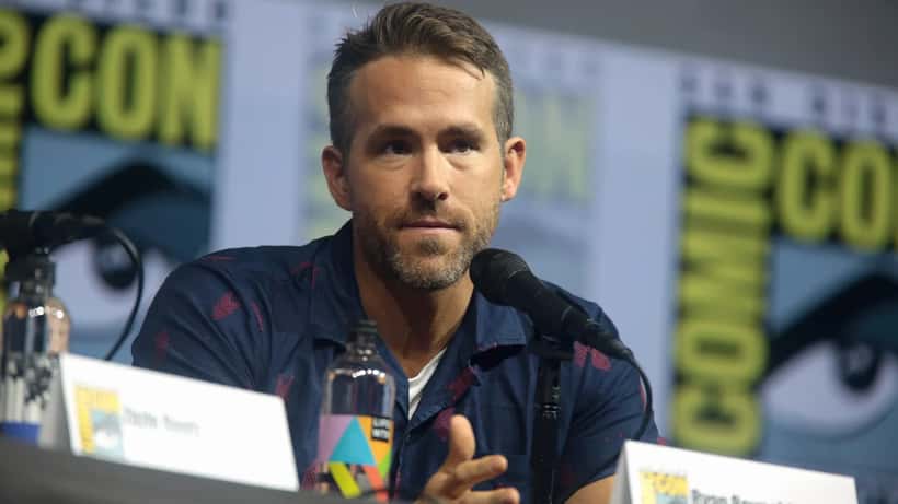 Ryan Reynolds at a public event, smiling at the camera
