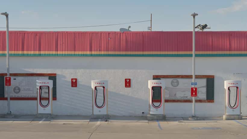 Posto Tesla Supercharger V4 com coluna de carregamento elétrico em área de estacionamento