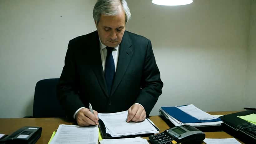 Avocat parisien examinant un dossier de fraude financière avec des relevés bancaires frauduleux