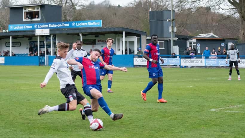 Football players contesting a tackle during a grassroots match
