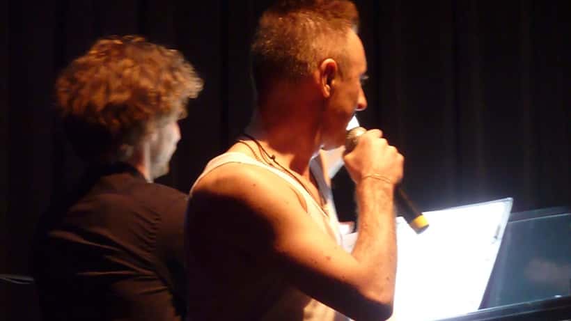 Alan Cumming speaking at a public event, host of the 2026 BAFTA Film Awards