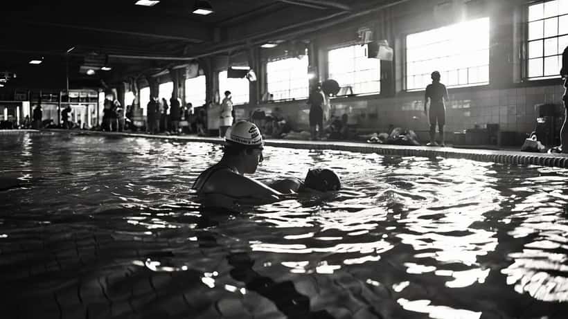 Secouriste réalisant un massage cardiaque sur le bord d'une piscine intérieure parisienne
