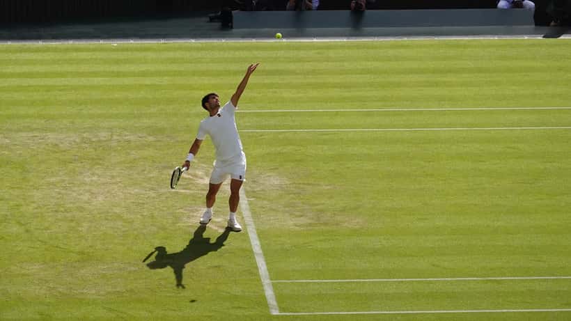 Carlos Alcaraz i serveposition på tennisbanan under Wimbledon 2025