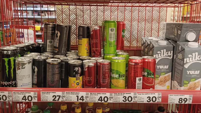 Colourful canned energy drink beverages including Red Bull and Monster