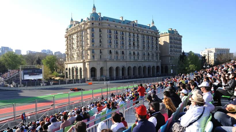 Luxury hotel overlooking the Baku City Circuit during the Azerbaijan Formula 1 Grand Prix, with race cars on the street circuit