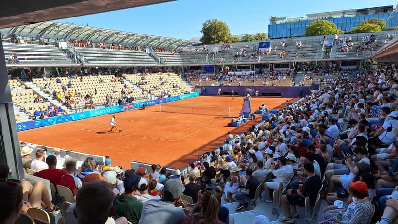 Stefanos Tsitsipas en action lors d'un match de tennis professionnel, représentant les enjeux de la gestion de carrière sportive