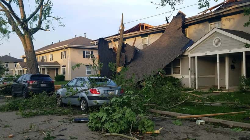 Maison avec toiture endommagée après une tornade, évaluation des dégâts structurels