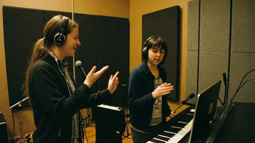 Coach de chant guidant une étudiante dans un studio de musique à Montréal