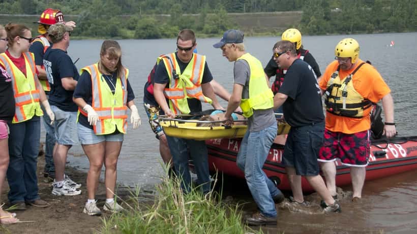 Räddningstjänstpersonal genomför vattenlivräddningsövning vid sjö
