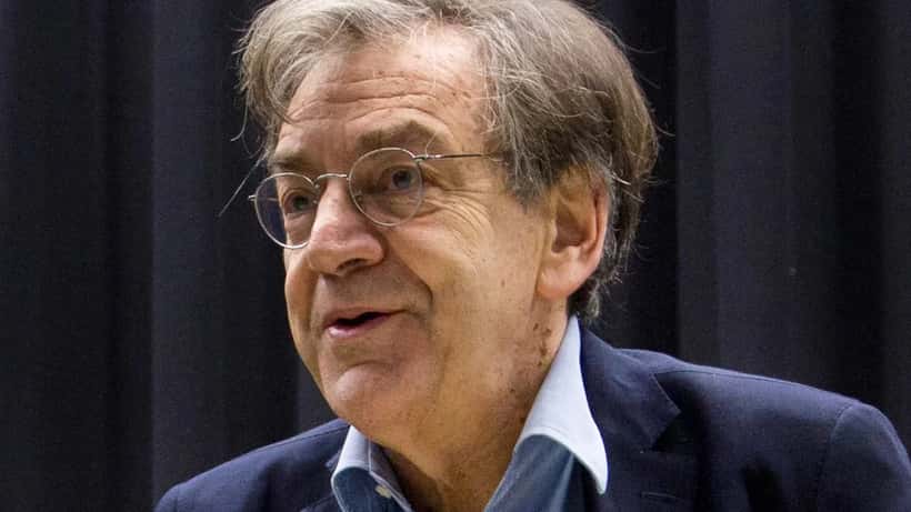 Avocat en droit pénal examinant des documents relatifs à des menaces en ligne dans un bureau parisien