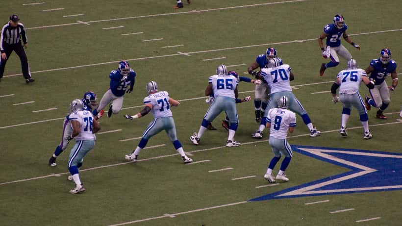 Match de football américain Cowboys vs Giants NFL, joueurs en plein contact lors d'un plaquage sur terrain