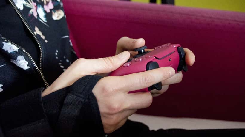 Person håller i en PS5 DualSense-kontroller