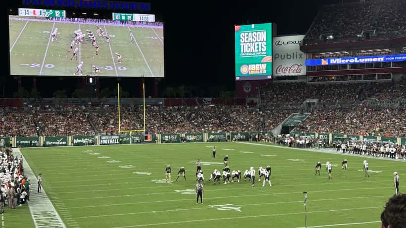 Miami Hurricanes players competing in a college football game against a rival team