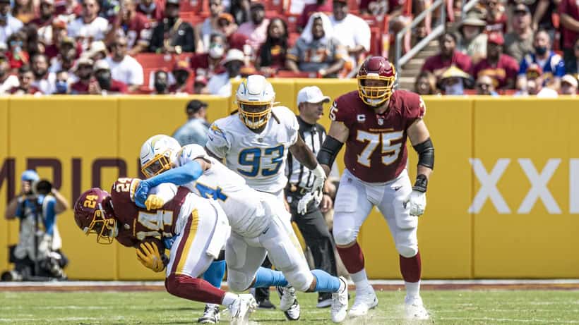 NFL player Kyzir White executing a tackle on the football field during an American football game