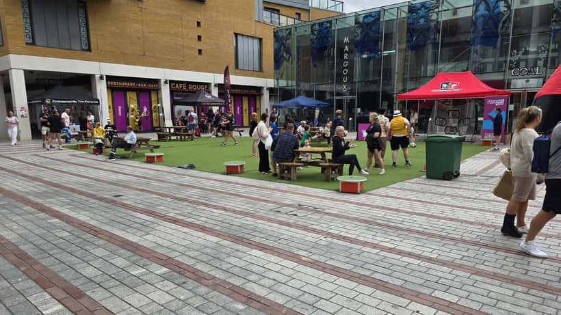 Rugby fans gathering at a Rugby World Cup event with team banners and stadium in background