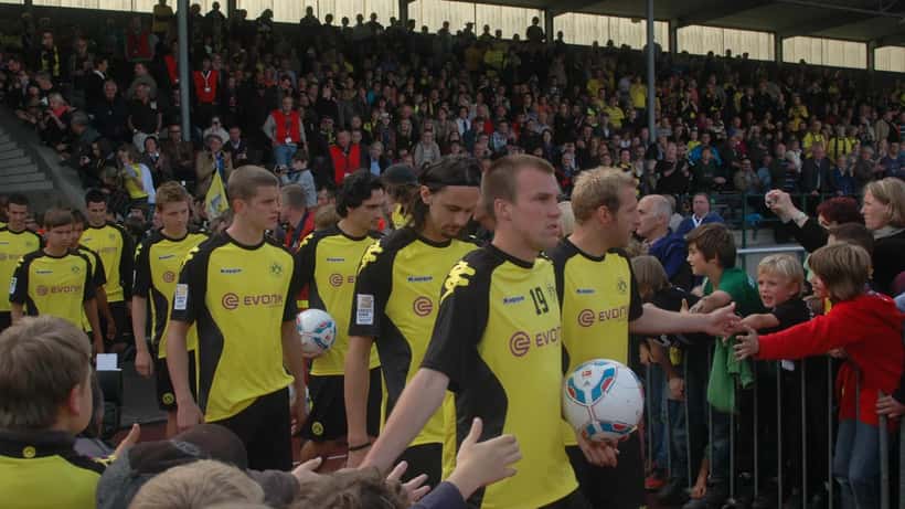 BVB-Fans und Spieler vor einem Bundesliga-Spiel in der Stadionatmosphäre