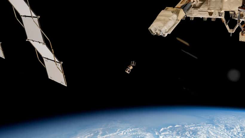 Small satellites deployed from the ISS into low Earth orbit, representing AST SpaceMobile BlueBird satellite internet technology