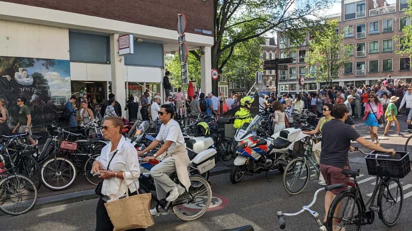 Feestende bezoekers bij Amsterdam Gay Pride festival met kleurrijke vlaggen en muziek