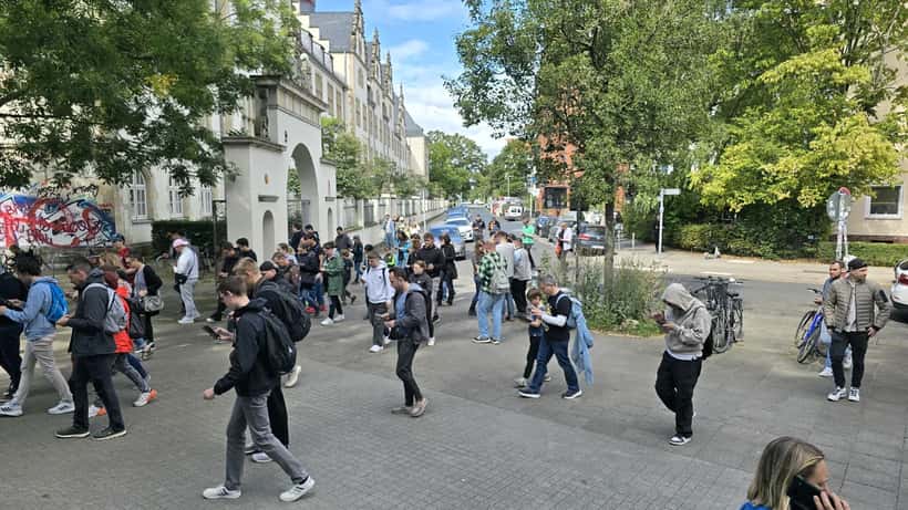 Jugendliche spielen Pokémon Go in einer Hannoverschen Straße und schauen auf ihre Smartphones