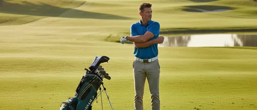 British male golfer stretching on a lush green golf course fairway in the morning light
