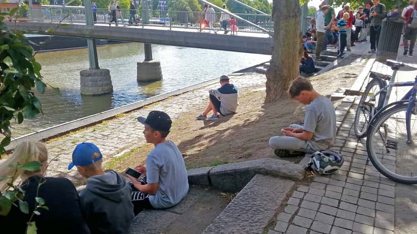 Children playing Pokémon GO outdoors on smartphones