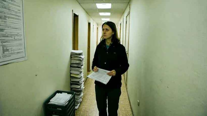 Erlend kona með leigusamning í þröngum íbúðargangi á Reykjavík